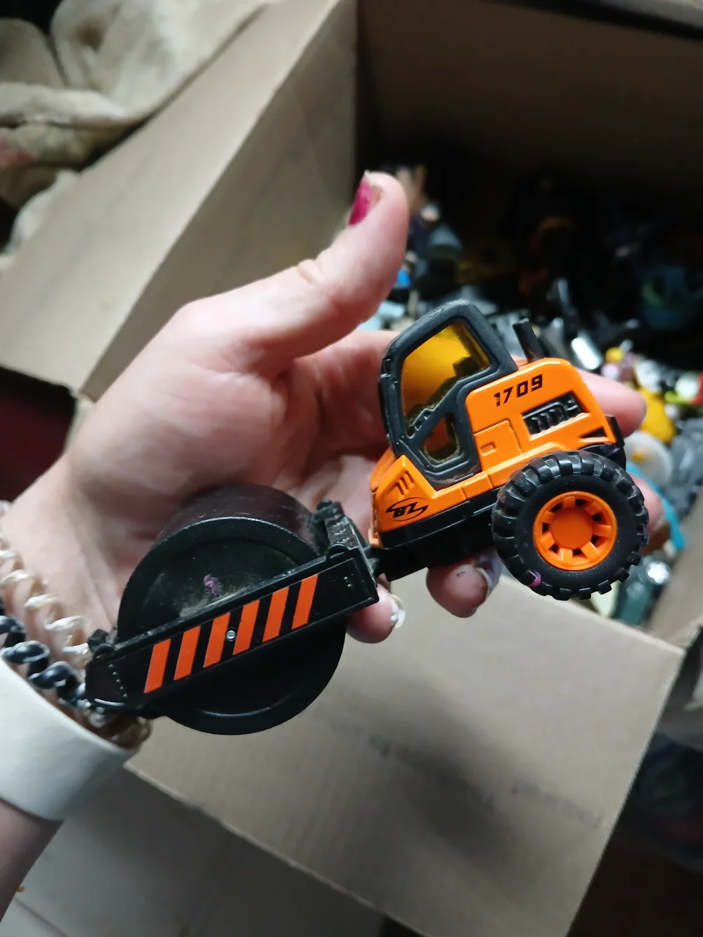 die-cast orange road roller toy Maisto